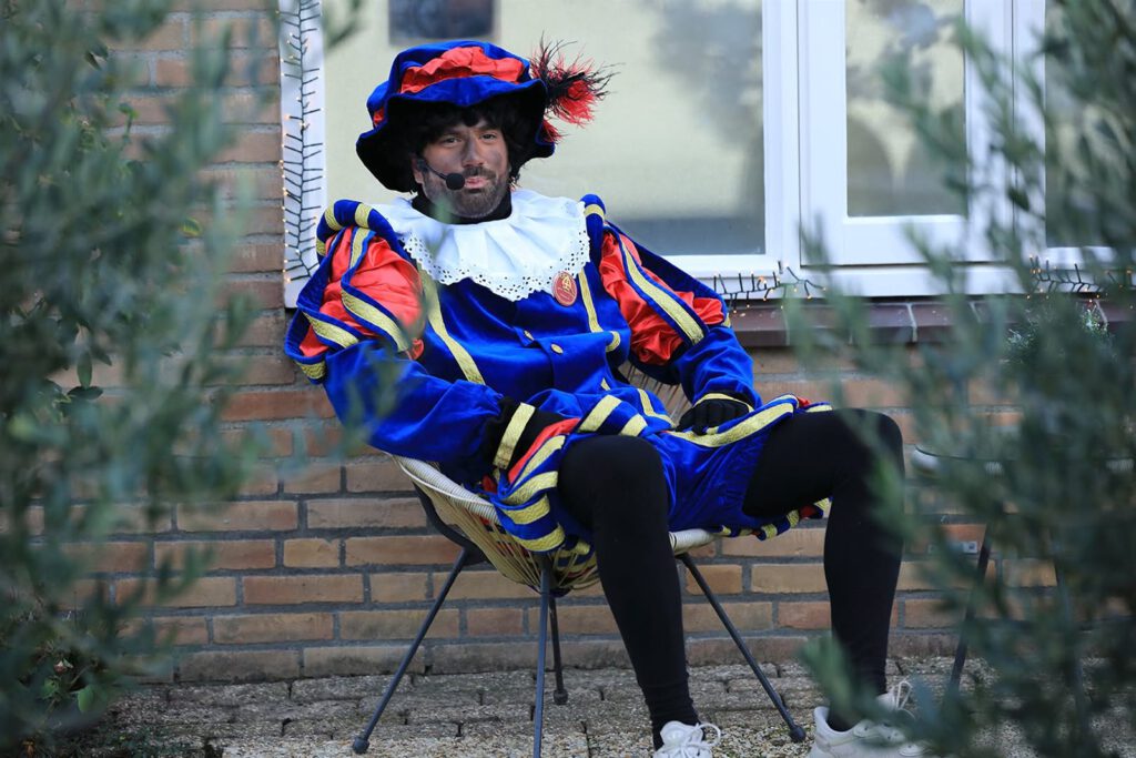Piet wacht voor de deur bij een huisbezoek