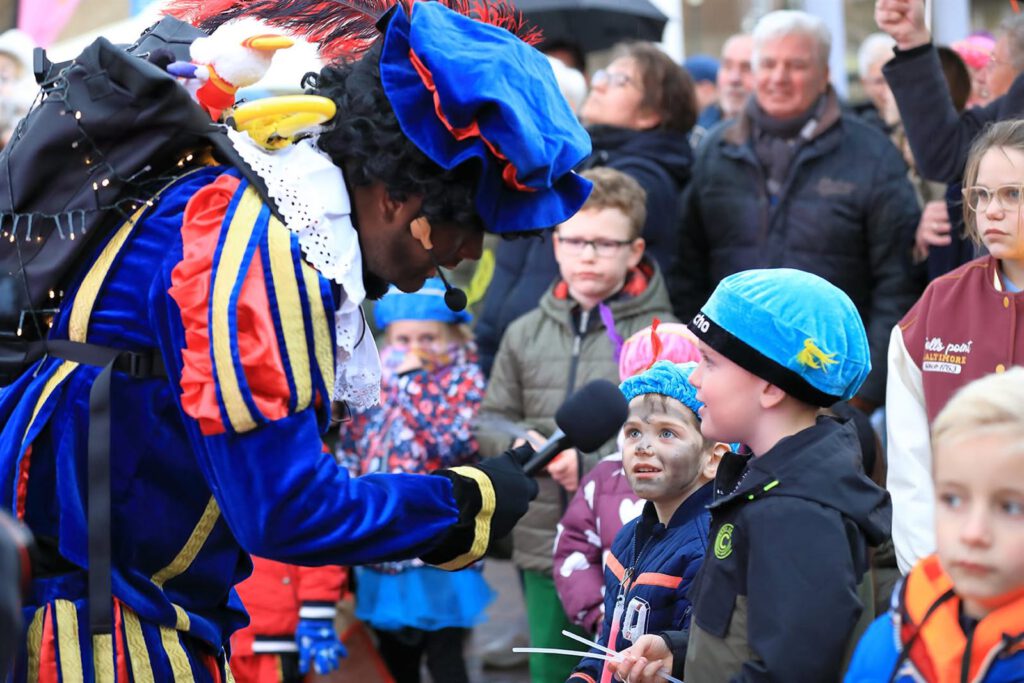 Piet in gesprek met kinderen langs de route